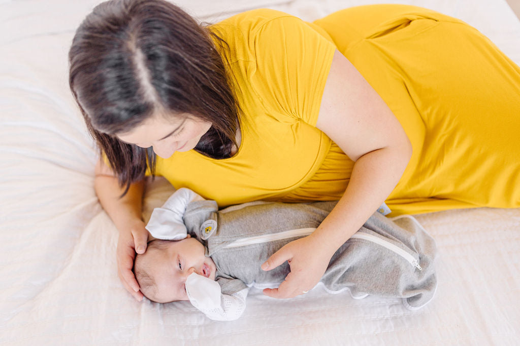 woman in yellow dress, baby with half-up sleeves sleep sack sleeping